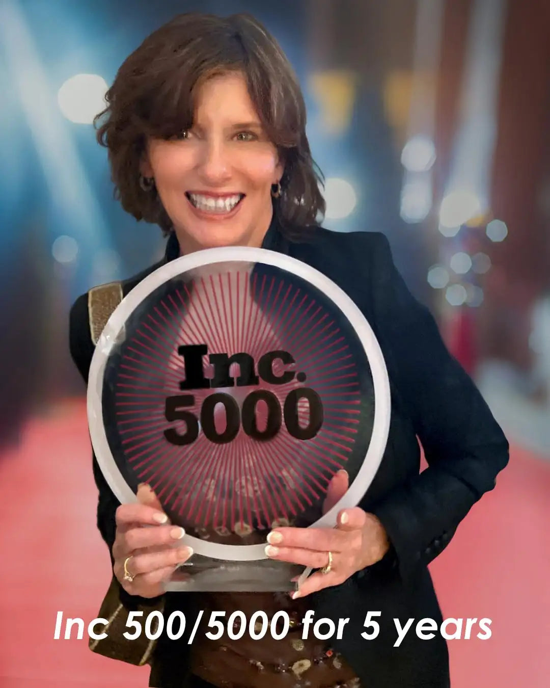 A circular, transparent acrylic award with a white rim and black ’inc.