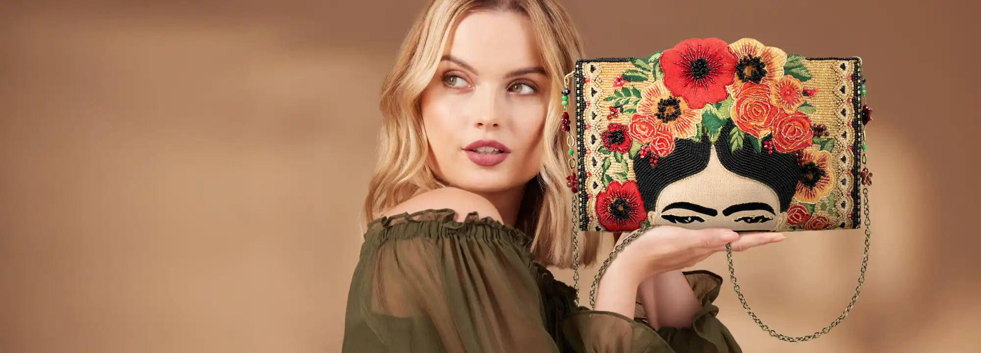 An embroidered clutch bag featuring a stylized depiction of Frida Kahlo’s face surrounded by colorful flowers.