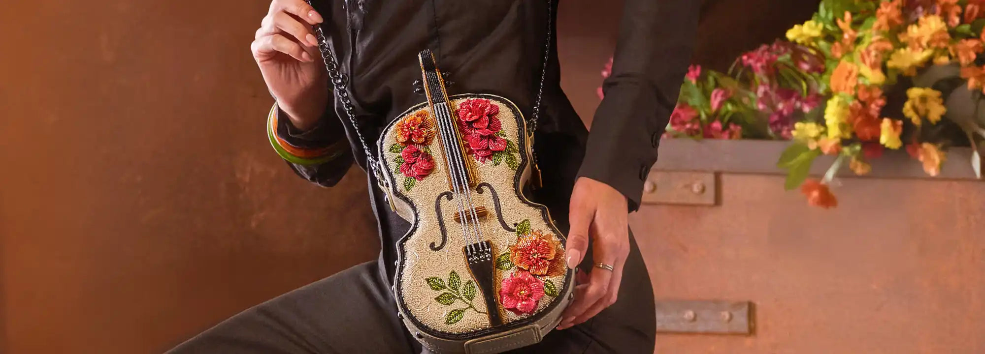 A white violin-shaped handbag with floral embellishments.
