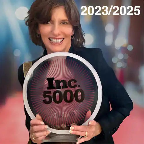 A woman holding a circular award with ’Inc. 5000’’ written on it.